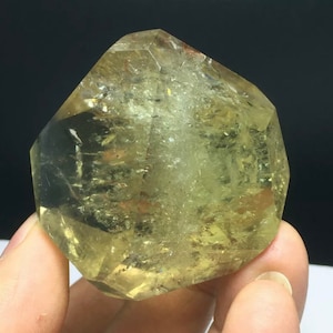 Op de afbeelding: Een groot, helder, gefacetteerd, geel citrien kristal met een punt aan de bovenkant. Het kristal is ongeveer 7,5 cm hoog en 5 cm breed.