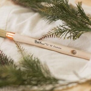 May include: A close-up of a wooden paint brush with a natural bristle head. The brush is labeled "Rust-Oleum" and "Lil' Frenchie".