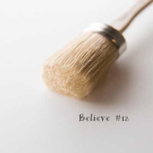 May include: A close-up of a round paint brush with natural bristles. The brush is attached to a wooden handle and has a silver metal ferrule. The text "Believe #12" is written below the brush.