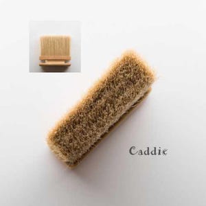 May include: A natural bristle brush with a wooden handle. The brush is designed for cleaning and polishing shoes.