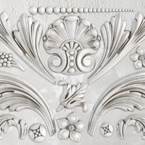 May include: A set of decorative metal moldings with intricate designs, including scrolls, leaves, and floral patterns. The moldings are in a silver color and have a smooth, polished finish.