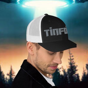 May include: A black and white trucker hat with a grey embroidered logo that says "Tin Foil".