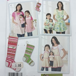 May include: A Simplicity sewing pattern for making aprons for adults and children. The pattern includes instructions for making a variety of styles, including a classic apron with pockets, a ruffled apron, and a simple apron with a heart-shaped neckline. The pattern also includes instructions for making matching stockings for a doll.