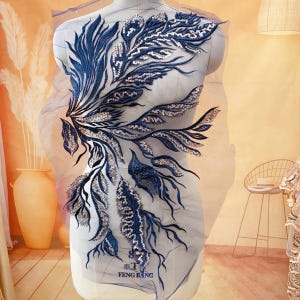 May include: A navy blue and silver sequined applique with a floral design. The applique is on a sheer mesh fabric. The text "FENG BANG" is visible in the bottom right corner of the image.