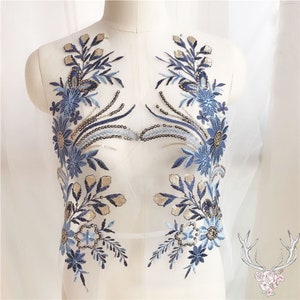 May include: Blue and gold floral applique embroidery with sequins. This delicate lace trim is perfect for adding a touch of elegance to any project.