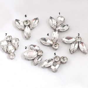 Peut inclure: Sept embellissements en cristal transparent de différentes formes et tailles, parfaits pour ajouter de l'éclat aux objets artisanaux et aux vêtements.