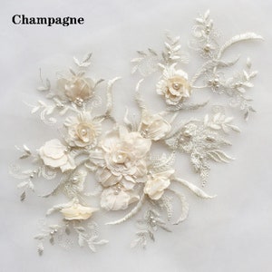 May include: A delicate floral applique with white flowers and pearl accents. The applique is perfect for adding a touch of elegance to clothing, accessories, or home decor.