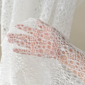 May include: White lace fabric with a delicate circular pattern. The lace is soft and sheer, with a delicate texture.