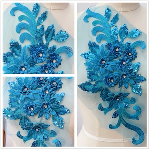 Può includere: Un'applicazione floreale blu turchese con paillettes e strass. L'applicazione è su un tessuto di rete trasparente.