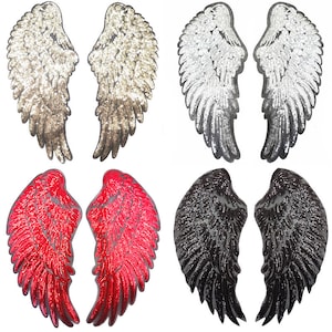 Puede incluir: Cuatro pares de alas de ángel de lentejuelas en dorado, plateado, rojo y negro. Cada par está hecho de lentejuelas y tiene una forma puntiaguda.