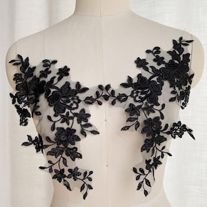 Puede incluir: Aplique de encaje floral negro con delicados diseños florales. El encaje está sobre una tela de malla transparente y es perfecto para agregar un toque de elegancia a cualquier proyecto.