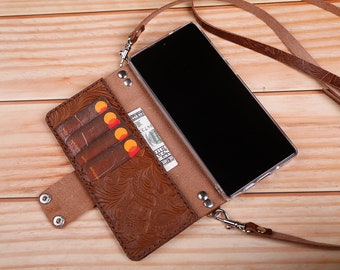 May include: A brown leather phone case with an embossed floral design. The case has slots for credit cards and a pocket for cash. It also has a detachable strap for carrying the phone around the neck.
