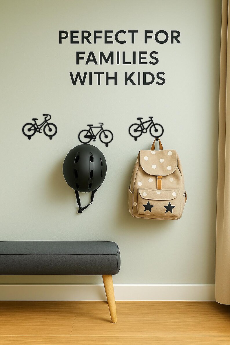 Op de afbeelding: Een wanddisplay met zwarte fietshaken, een zwarte helm en een beige rugzak met witte stippen en sterren. De tekst "PERFECT FOR FAMILIES WITH KIDS" staat boven de items.