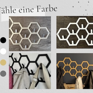 May include: A collage of honeycomb-shaped wall hooks in various colors: silver, white, black, and gold. The hooks are displayed with coats and bags, showcasing their functionality. The text "W&auml;hle eine Farbe" is at the top.