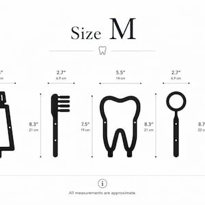Op de afbeelding: Een set van vijf zwarte wanddecoraties met een tandheelkundig thema, gelabeld als Maat M, inclusief een tandpastatube, tandenborstel, tand, tandartsspiegel en sonde. Elk item toont afmetingen in centimeters, vari&euml;rend van 3,8 tot 22 cm.