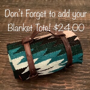 May include: A rolled-up blanket tote with brown leather handles and straps. The blanket has a turquoise, white, black, and beige geometric pattern. The text on the image says, "Don't Forget to add your Blanket Tote!"