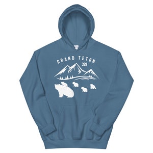 May include: A blue hooded sweatshirt with a white graphic design of mountains and bears. The text "GRAND TETON 399" is printed on the sweatshirt.