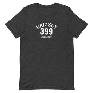 May include: Dark heather grey t-shirt with a white graphic print that says "Grizzly 399 Est. 1996".