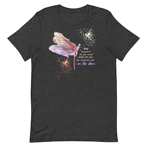 May include: A dark heather grey t-shirt with a watercolor dragonfly design and the text "They whispered to her you cannot withstand the storm she whispered back I am the storm".