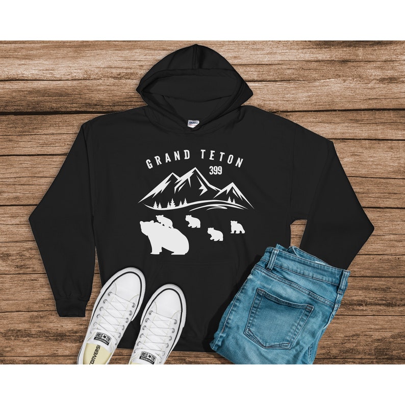 May include: Black hooded sweatshirt with a white graphic of mountains and bears. The text "GRAND TETON 399" is printed on the sweatshirt.