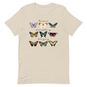 May include: A beige t-shirt with a graphic of colorful butterflies and the text "Become something amazing".