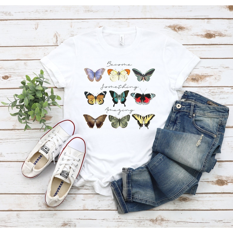 May include: White t-shirt with a graphic of colorful butterflies and the text "Become something amazing".
