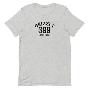 May include: A heather grey t-shirt with a black graphic print of "Grizzly 399 Est. 1996".
