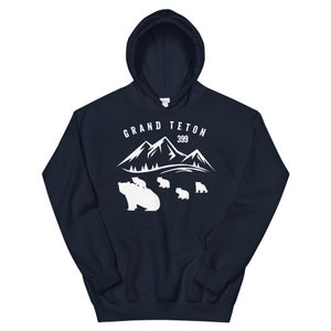 May include: Navy blue hooded sweatshirt with a white graphic of mountains and bears. The text "GRAND TETON 399" is printed on the sweatshirt.