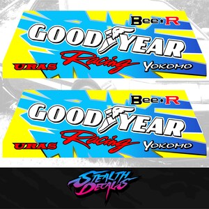 Puede incluir: Dos calcomanías con temática de carreras con el texto "GOOD YEAR Racing" en blanco y rojo, sobre un fondo azul y amarillo. Las calcomanías también presentan los logotipos de "Bee R", "URAS" y "Yokomo". La parte inferior de la imagen muestra el texto "STEALTH DECALS".