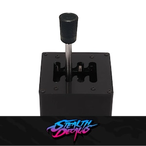 May include: Black gear shifter with a black knob and a silver shaft. The shifter has a rectangular base with multiple holes for mounting.