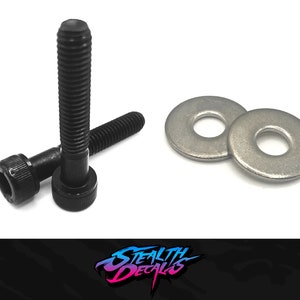 May include: Two black screws with a hexagonal head and a silver washer. The screws are lying on a white surface.
