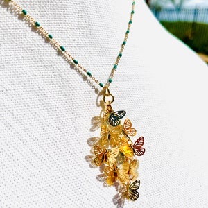 Dainty whimsical fluttering butterflies pendant on turquoise bead gold chain necklace