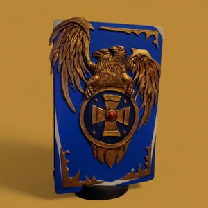 Puede incluir: Un escudo azul con un águila bicéfala dorada y un emblema de cruz dorada. El escudo tiene adornos dorados y una gema roja en el centro de la cruz. El escudo está sobre una base negra.