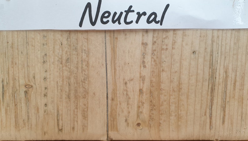 May include: A close-up of a light brown wood surface with a vertical grain pattern. The wood has a natural, unpainted finish. The word "Neutral" is written in black on a white label above the wood.