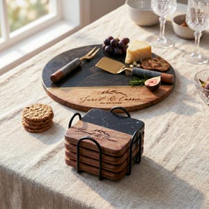a table with a marble coaster, a wooden platter with cheese and grapes, and a stack of coasters. The table also has a bowl, a wine glass, and a plate of crackers.