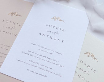 May include: A white wedding invitation with gold lettering. The invitation reads "Sophie and Anthony request the pleasure of your company at their marriage 2pm on Saturday, 6th August 2024 at St. Paul's Church, Brighton, Dyke Road, BN1 3RT followed by a reception at Stanmer House, Stanmer Village, Brighton BN1 9QA Carriages at midnight."