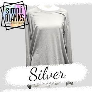 May include: A silver long-sleeved t-shirt on a mannequin. The shirt is plain with no design or graphics. The text "simpli BLANKS" and "simpliblanks.com" is visible in the top left corner of the image. The word "Silver" is written in cursive at the bottom of the image.