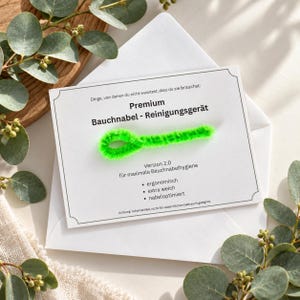 Könnte beinhalten: Eine weiße rechteckige Karte mit einem leuchtend neongrünen, flauschigen Pfeifenreiniger in Schlaufenform. Der Text lautet: Dinge, von denen du nicht wusstest, dass du sie brauchst: Premium Bauchnabel - Reinigungsgerät, Version 2.0, für maximale Bauchnabelhygiene, ergonomisch, extra weich, nabeloptimiert, Achtung: Scherzartikel, nicht für tatsächlichen Gebrauch geeignet.