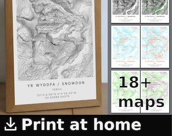 May include: A framed black and white topographic map of Yr Wyddfa, also known as Snowdon, the highest mountain in Wales. The map shows contour lines, elevation, and mountain features. The map is framed in a light brown wood frame. The text on the map reads "Yr Wyddfa / Snowdon 1085m 53°4'6.59"N 4°4'34.43"W SH 60989 54379".