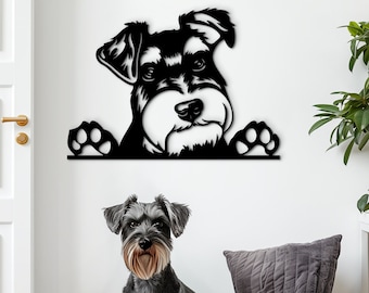 Könnte beinhalten: Schwarze Metallsilhouette eines Zwergschnauzers, der über eine Wand schaut. Ein echter Zwergschnauzer sitzt auf einem hellgrauen Sitzsack vor der Wandkunst.