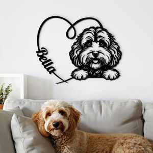 Può includere: Un ritaglio in metallo nero di una testa di cane all'interno di un cuore con il nome "Bella" scritto su di esso. Un cane marrone e bianco è sdraiato su un divano grigio.