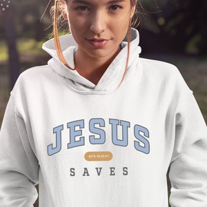 May include: White hoodie with blue text that reads "JESUS SAVES" and "ACTS 18:10-21" in a smaller font.