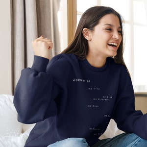 May include: A navy blue sweatshirt with the text "Jesus is... my Lord, my King, my Strength, my Hope, my Savior, my God, my Life" printed in white.