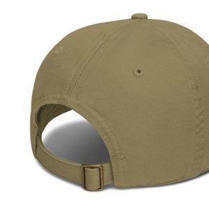 May include: A khaki colored baseball cap with a brown adjustable strap and buckle.