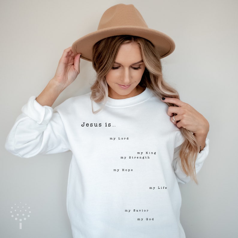 May include: White sweatshirt with the text "Jesus is..." followed by a list of phrases: "my Lord", "my King", "my Strength", "my Hope", "my Life", "my Savior", "my God".