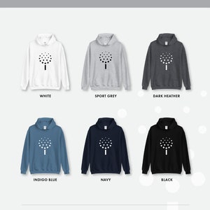 May include: Six different color hoodies with a white tree design printed on the front. The colors are white, sport grey, dark heather, indigo blue, navy, and black.
