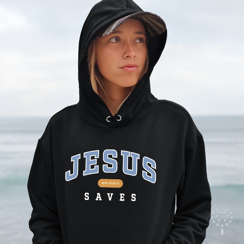 May include: Black hooded sweatshirt with the text "JESUS SAVES" in blue and white lettering. The text "ACTS 16:30-31" is printed in small font below the main text.