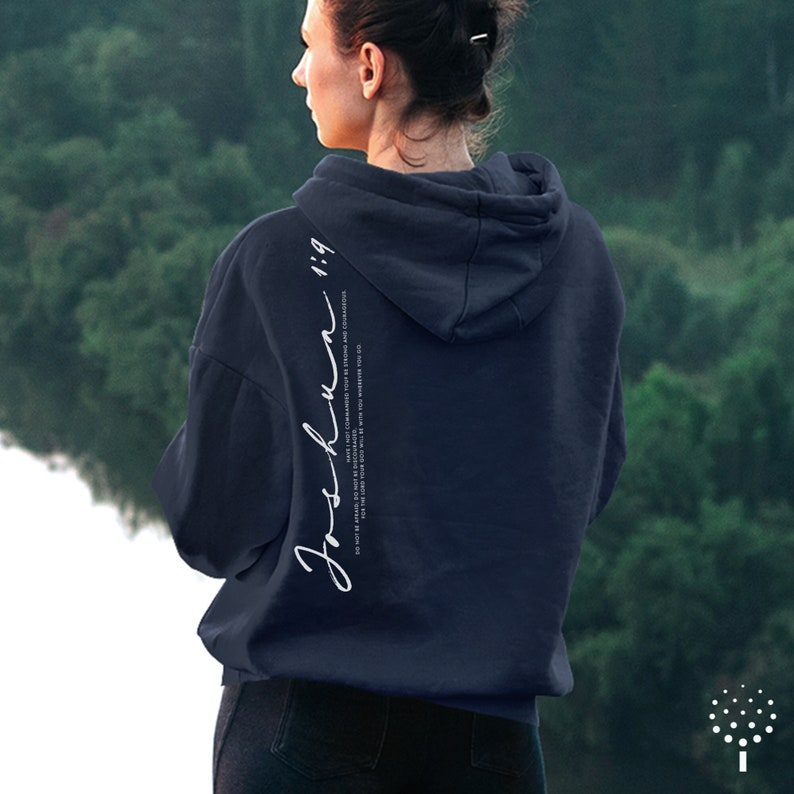 May include: A navy blue hooded sweatshirt with the text "Joshun 1:9" printed on the back. The text is in white and is written in a cursive font.