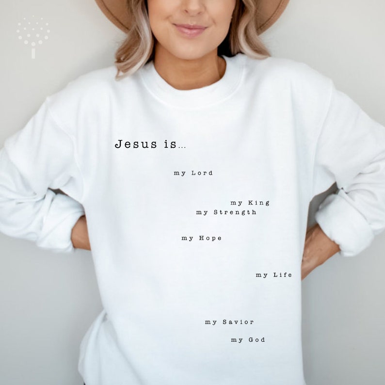 May include: White sweatshirt with the text "Jesus is..." followed by a list of phrases describing Jesus, including "my Lord", "my King", "my Strength", "my Hope", "my Life", "my Savior", and "my God".