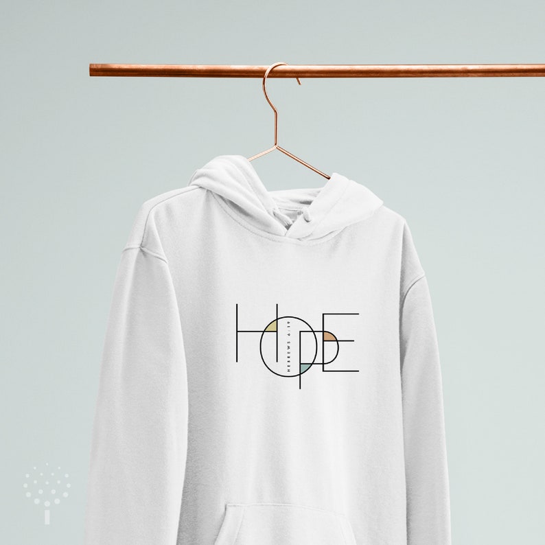 May include: White hoodie with a black graphic of the word "HOPE" in a geometric design with a circle containing colourful shapes.